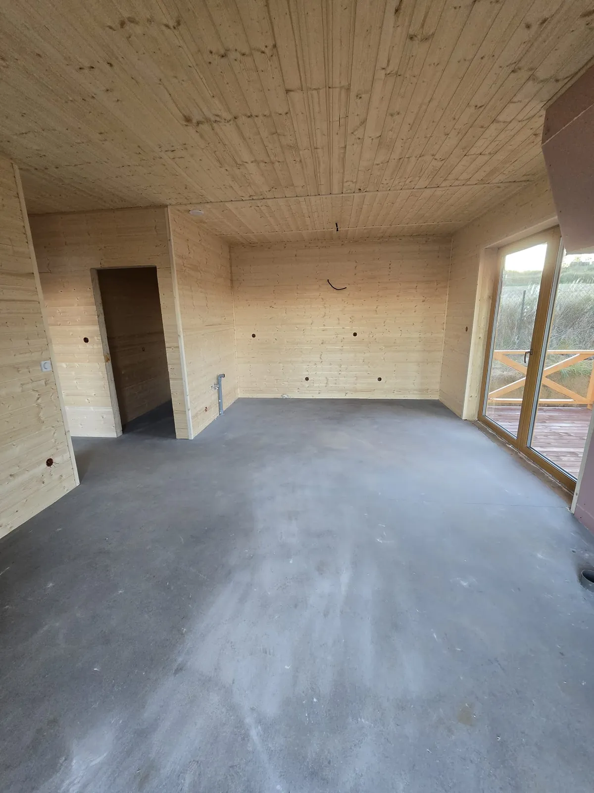 Wnętrze domu drewnianego 86 m² z dużym oknem tarasowym, przed wykończeniem